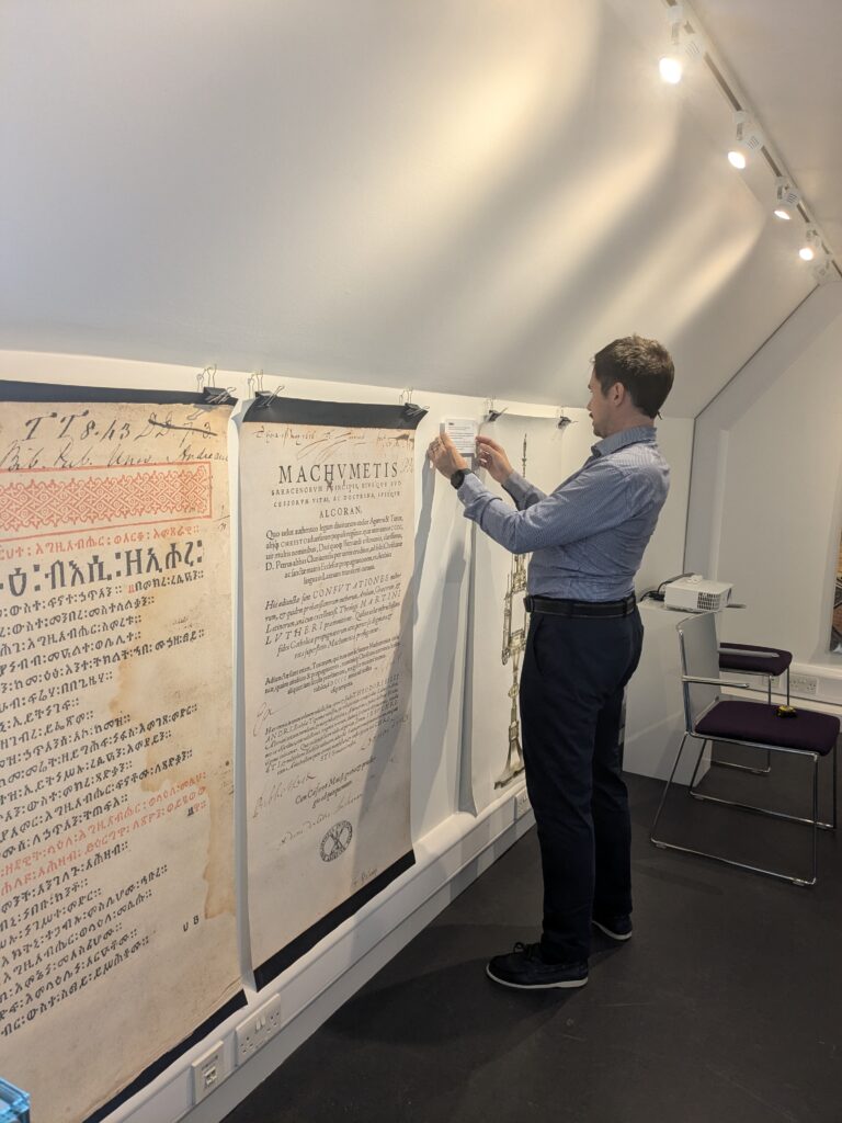 A man installs a label on a museum wall.