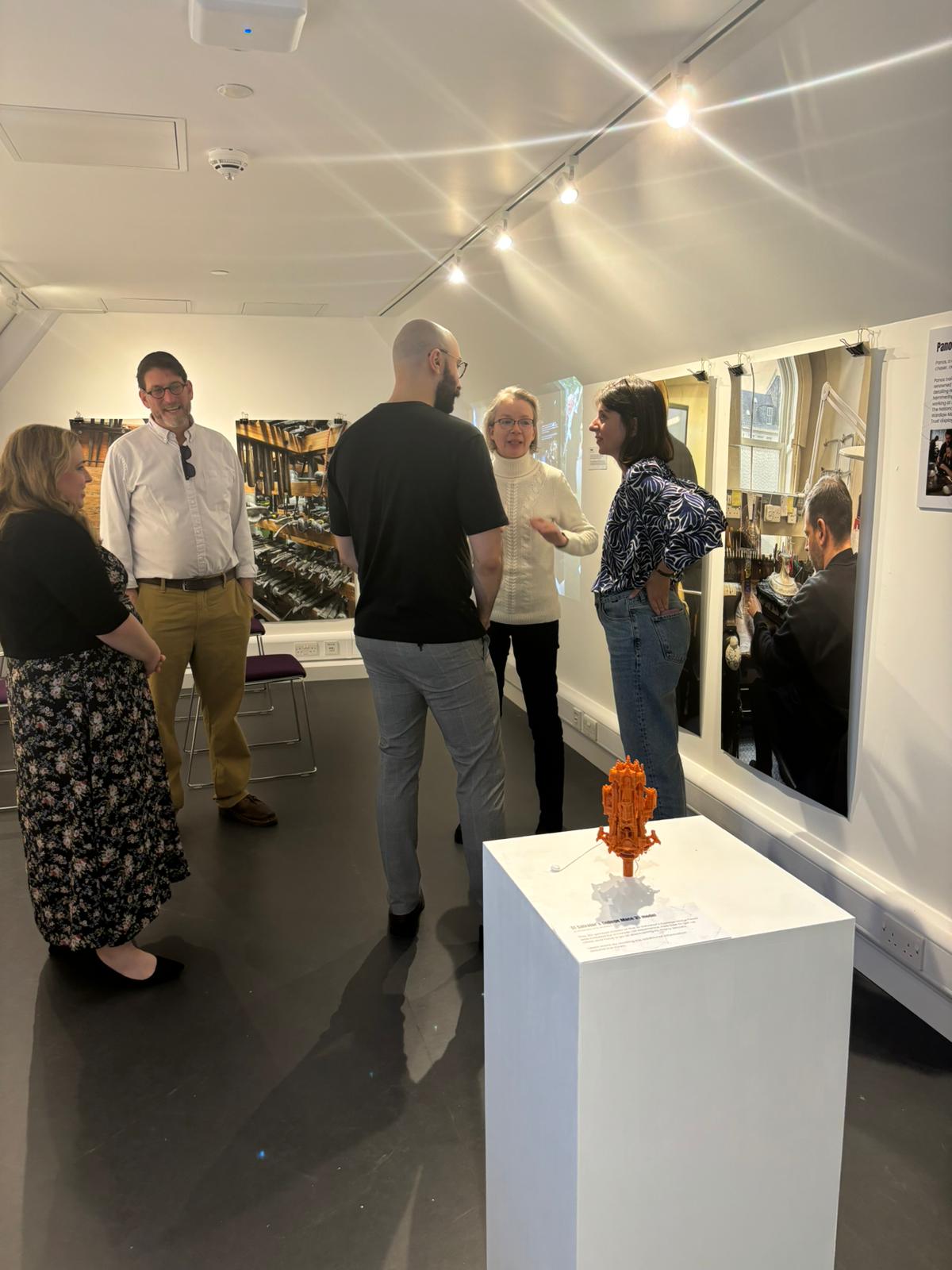 A group of people looking at a museum exhibit and discussing it.